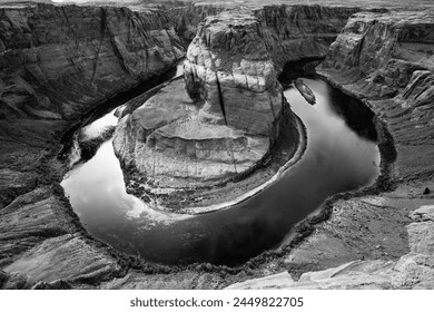 Horseshoe Bend is a horseshoe-shaped incised meander of Colorado River near Page, Arizona, USA, part of Grand Canyon. Panoramic view of river loop. Major tourist attraction sight, black and white.