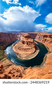 Horseshoe Bend is a meander of Colorado River near Page, Arizona, USA and part of Grand Canyon. Panoramic wide angle view of river loop and colorful red sandstone. Major sight on a sunny spring day.