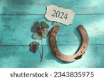 Horseshoe with lucky clover - 2024 greeting card - horseshoe with ladybird on wooden background - happy new year and birthday greetings, wishes
