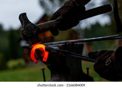 Horseshoe production process. A blacksmith bending hot metal on an anvil - Powered by Shutterstock