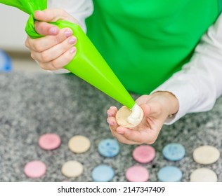 Hosewife With Confectionery Bag Squeezing Cream Filling To Macarons Shells