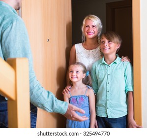 Hospitable Man Greeting Cheerful  Smiling Guests At Apartment Entrance
