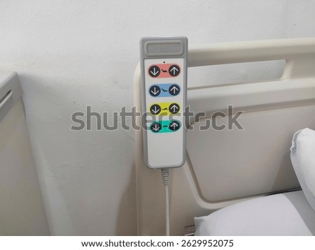 a hospital bed control panel with multiple color-coded buttons for adjusting bed position. Taken in a hospital room
