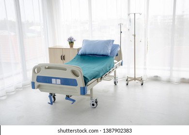 Hospital Bed With No Patient  In The Hospital Room And Iv Stand With Pillow And Blanket