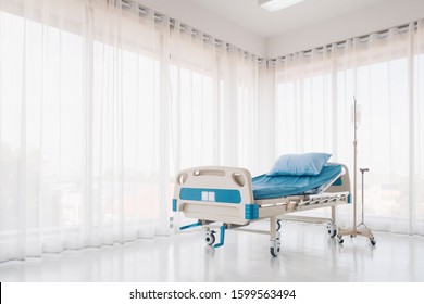 Hospital Bed With Pillow And Blanket And Intravenous (IV) Stand, No Patient In The Room In The Modern Hospital. Healthcare, Medical Insurance Concept.