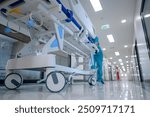 A hospital bed trolley being pushed down a clean, white hallway as other hospital bed trolleys push patients