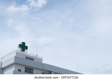 Hospital Building And Green Medical Cross Sign. Concept Of Medical Background.