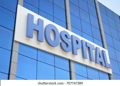 Hospital Building Sign Closeup, With Sky Reflecting In The Glass. 3d Rendering