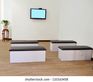 Hospital Or Clinic Waiting Room With Stools And Flat Screen TV.