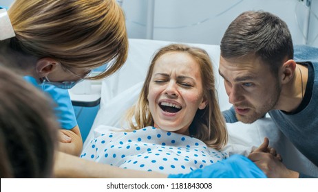In the Hospital Close-up on Woman in Labor Pushes to Give Birth, Obstetricians Assisting, Husband Holds Her Hand. Modern Delivery Ward with Professional Midwives. - Shutterstock ID 1181843008