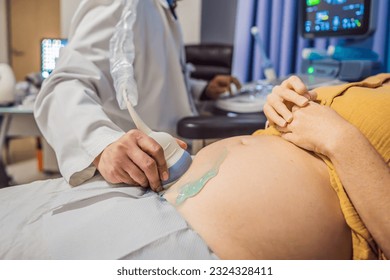 In the Hospital, Close-up Shot of the Doctor does Ultrasound Sonogram Procedure to a Pregnant Woman. Obstetrician Moving Transducer on the Belly of the Future Mother - Powered by Shutterstock