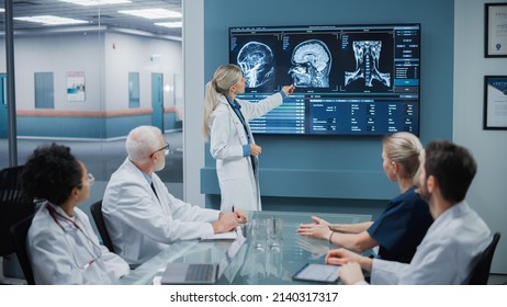 Hospital Conference Meeting Room: Female Physician Presents Patient X-Ray on TV Screen, Team of Medical Doctors Discuss Patient Treatment. Research Scientists Talk of Cure, Drug, Medicine Development - Powered by Shutterstock