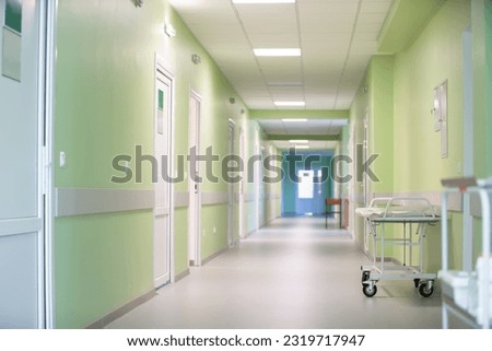 Hospital corridor with green walls and a medical gurney.