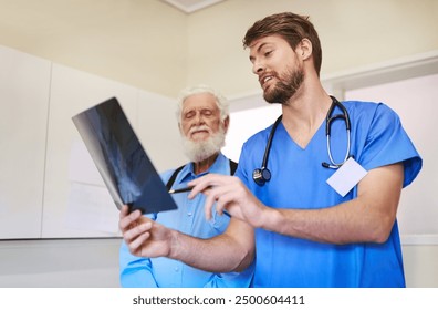 Hospital, discussion and nurse with xray by man for body injury, diagnosis and medical assessment. Elderly person, patient and professional with radiology scan for arthritis, evaluation and treatment - Powered by Shutterstock