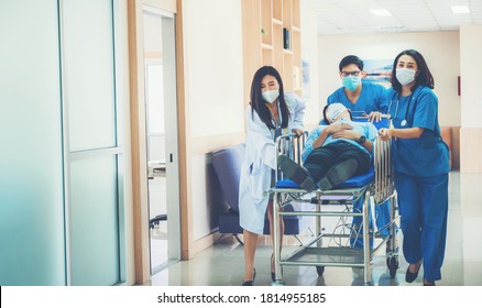 Hospital Emergency Doctor Team And Nurse Staff Carrying Stretcher With Patient From The Accident Ambulance Running To The Surgery Room