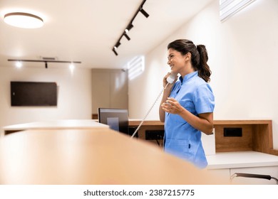 Hospital front desk receptionist talking on the phone and making doctor appointment. - Powered by Shutterstock