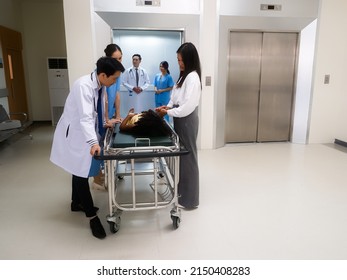 At Hospital Hall Doctor And Nurse Looking At Patient To Treatment Room While Doctor And Nurse In Elevator
