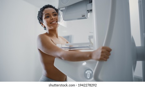 In the Hospital, Happy Smiling Topless Latin Female Patient with Short Hair Undergoing Mammography Screening Procedure. Healthy Young Female Does Cancer Preventive Mammogram Scan in Radiology Room.