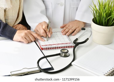 Hospital And Health Care Concept, Doctor And Patient Make An Appointment For Follow Up Plan, Physician Point At A Calendar.