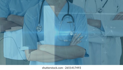 In hospital, healthcare professionals in scrubs reviewing image of medical data graphics. analysis, teamwork, collaboration, technology