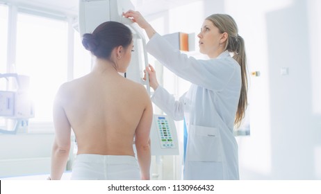 In the Hospital, Mammography Technologist / Doctor adjusts Mammogram Machine for a Female Patient. Friendly Doctor Explains Importance of Breast Cancer Prevention Screening. Modern Clinic.
