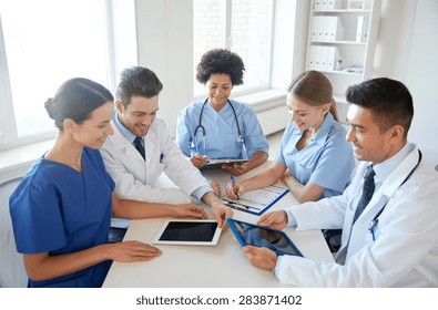 Hospital, Medical Education, Health Care, People And Medicine Concept - Group Of Happy Doctors With Tablet Pc Computers Meeting At Medical Office