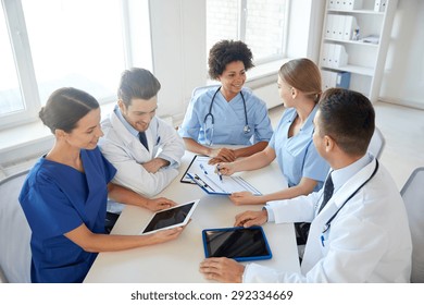 Hospital, Medical Education, Health Care, People And Medicine Concept - Group Of Happy Doctors With Tablet Pc Computers Meeting At Medical Office