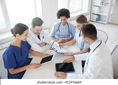 Hospital, Medical Education, Health Care, People And Medicine Concept - Group Of Happy Doctors With Tablet Pc Computers Meeting At Medical Office