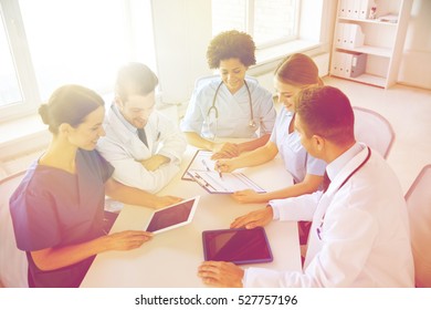 Hospital, Medical Education, Health Care, People And Medicine Concept - Group Of Happy Doctors With Tablet Pc Computers Meeting At Medical Office