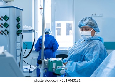 Hospital medical staff. Healthcare workers in protective gear operate medical equipment while attending to patients in a hospital setting during the day. - Powered by Shutterstock