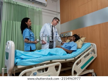 In hospital nurse and doctor talking greeting with patient to let him know illness condition to boost up morale
