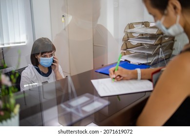 At The Hospital, The Nurse On Duty Speaks On The Phone At The Reception Desk. Busy Modern Hospital With Some Of The Best Specialists And Medicare In The Country.