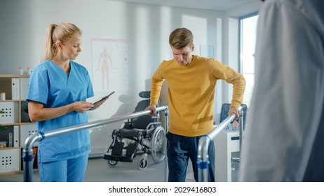 Hospital Physical Therapy: Determined Male Patient With Injury Successfully Walks His First Steps Holding Parallel Bars. Physiotherapist, Rehabilitation Doctor Encourage, Applaud Disabled Person