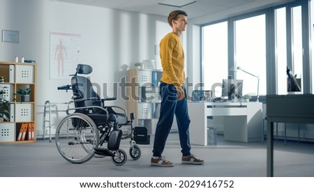 Hospital Physical Therapy: Determined Young Man with Injury Successfully Stands up from Wheelchair and Walks. Miracle of Rehabilitation, Strong Mindedness, Willpower, Professional Doctors.