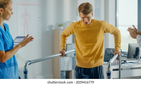 Hospital Physical Therapy: Portrait Of Strong Male Patient With Injury Successfully Walks Holding Parallel Bars. Physiotherapist, Rehabilitation Doctor, Help, Assist, Disabled Person.