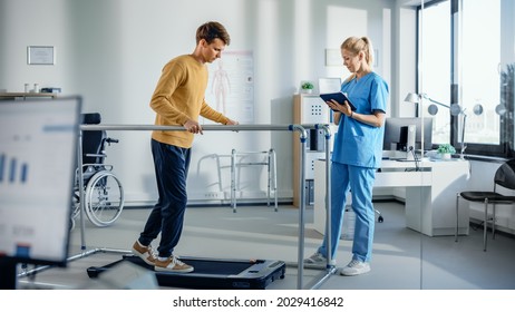 Hospital Physical Therapy Room: Patient with Injury Walking on Treadmill Holding for Parallel Bars, Professional Physiotherapist Assists, Helps, Trains Disabled Person Do Rehabilitative Physiotherapy - Powered by Shutterstock