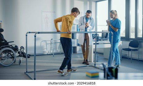 Hospital Physical Therapy: Strong Patient with Injury Making First Steps, Walks Holding for Parallel Bars. Physiotherapist, Rehabilitation Doctor Assist, Help Disabled Person. - Powered by Shutterstock