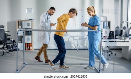 Hospital Physical Therapy: Strong Patient With Injury Making First Steps, Walks Holding For Parallel Bars. Physiotherapist, Rehabilitation Doctor Assist, Help Disabled Person.