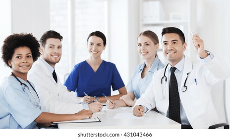 Hospital, Profession, People And Medicine Concept - Group Of Happy Doctors Meeting And Asking Questions On Conference At Hospital