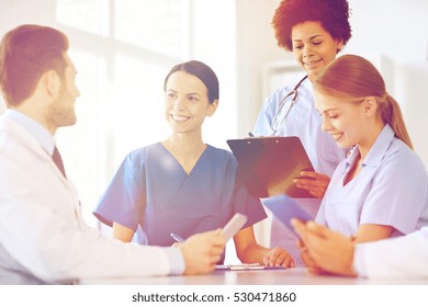 Hospital, Profession, People And Medicine Concept - Group Of Happy Doctors With Tablet Pc Computers Meeting At Medical Office