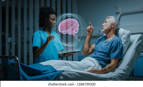 In the Hospital, Senior Patient Lying in the Bed Nurse Holding Tablet Computer Shows Augmented Reality Brain Scan. They Both Make Gestures and Talk. In the Technologically Advanced Hospital Ward.