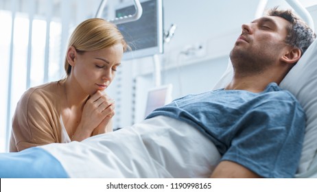 In the Hospital Sick Man Lying on the Bed, His Visiting Wife Sorrowfully Sits Beside Him and Prays for His Rapid Recovery.