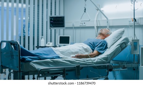 In the Hospital Sick Man Rests, Lying on the Bed. Recovering Man Sleeping in the Modern Hospital Ward. - Powered by Shutterstock