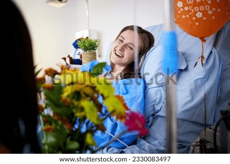 Hospital, sick patient and visitor with flowers at bed with a woman in recovery with support. Healthcare, medical insurance and person with bouquet, family and care with get well soon balloons