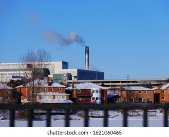 Hospital Smoke Stake With Steam Coming Our With Blue Sky. Out Of Focus Fence In Foreground