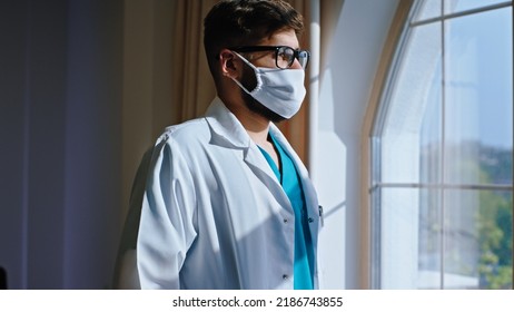 In The Hospital In Stuff Room Young Man Doctor With A Chin And Eye Glasses Have A Break He Looking Through The Panoramic Room