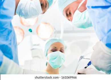 Hospital - Surgery Team In Operating Room Or Op Of A Clinic Operating On A Patient In An Emergency Situation