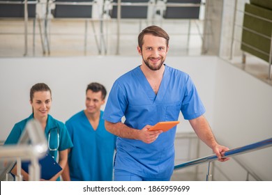 In The Hospital. Three Doctors Going Up The Stairs And Talking