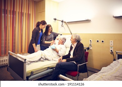 Hospital visit family with patient in bed