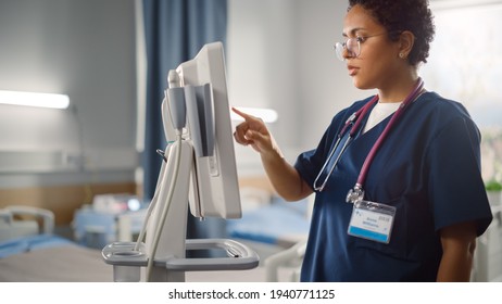 Hospital Ward: Beautiful Black Female Head Nurse, Doctor, Surgeon Uses Health Care Vitals Monitoring Computer Machine. Modern High Tech Clinic With Advanced Equipment And Professional Staff